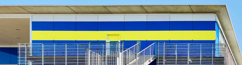Photo of the blue fassade of the MPI Biology Building with a yellow stripe on it.
