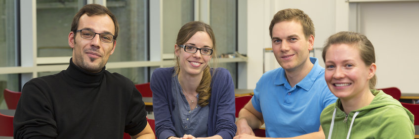 Photo of 4 students sitting together looking at the camera